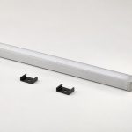 Display cabinet lighting concept showing a slim silver bar, white cover, separate black mounting clips and an end cable