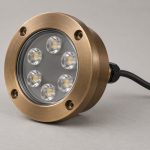 Underwater boat light concept with a round bronze-toned body, clear front window, visible lenses and a black rear cable
